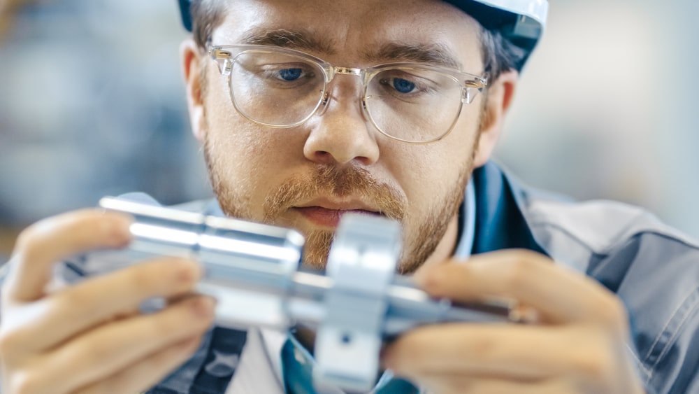 Engineer inspecting metal part