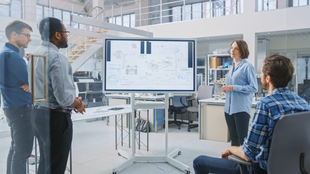 Four people looking at a monitor