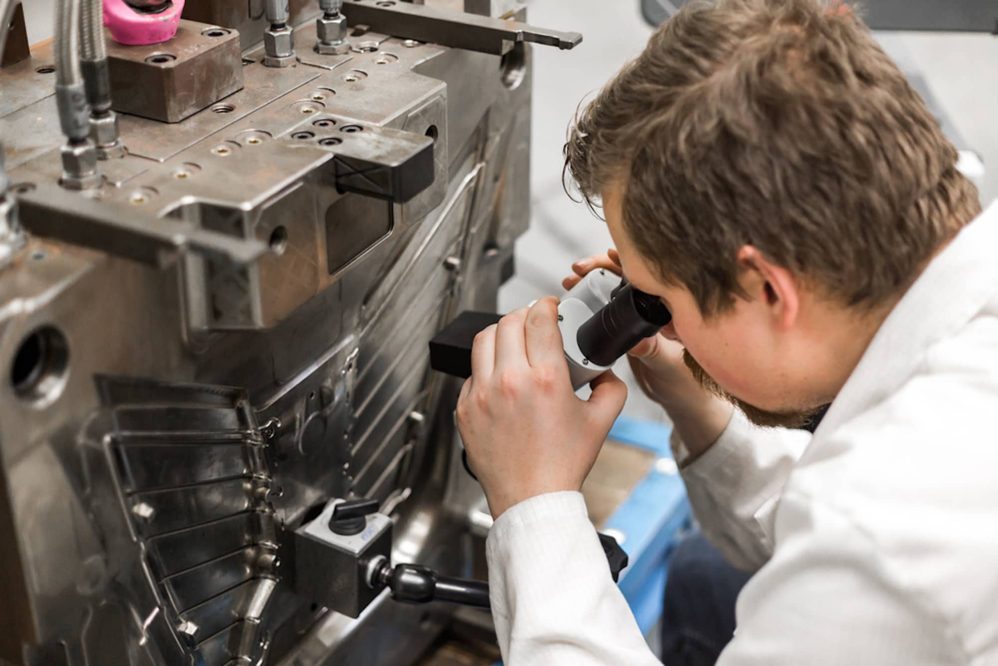 man inspecting injection molding part