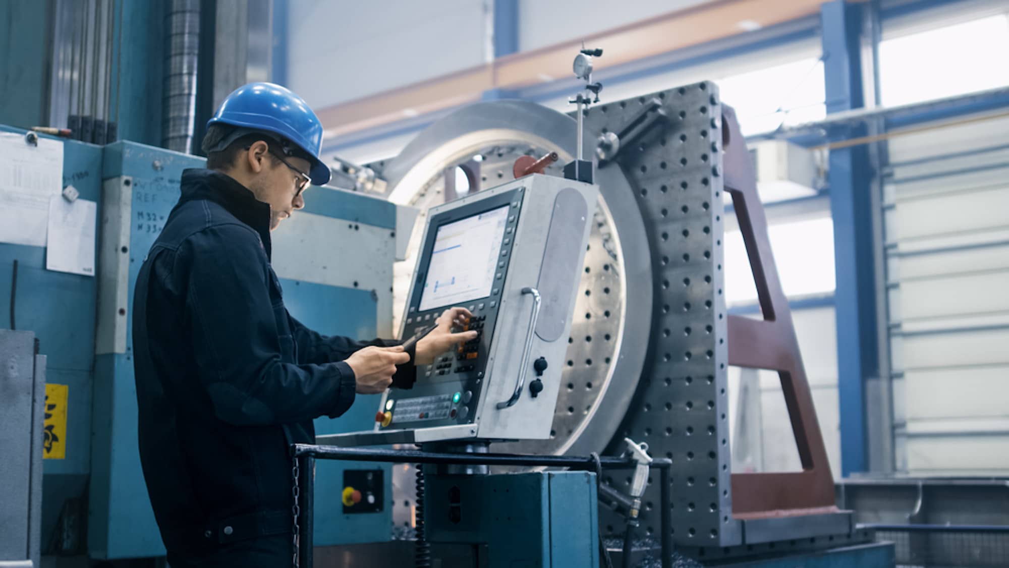 man at machine in factory pressing buttons manufacturing automation