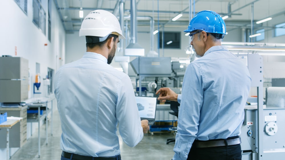 Men looking at tablet in factory